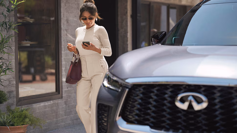 Infiniti owner walking beside her infiniti vehicle